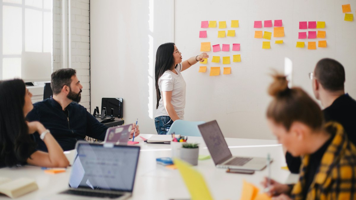 Team discussing ideas on a wall of sticky notes