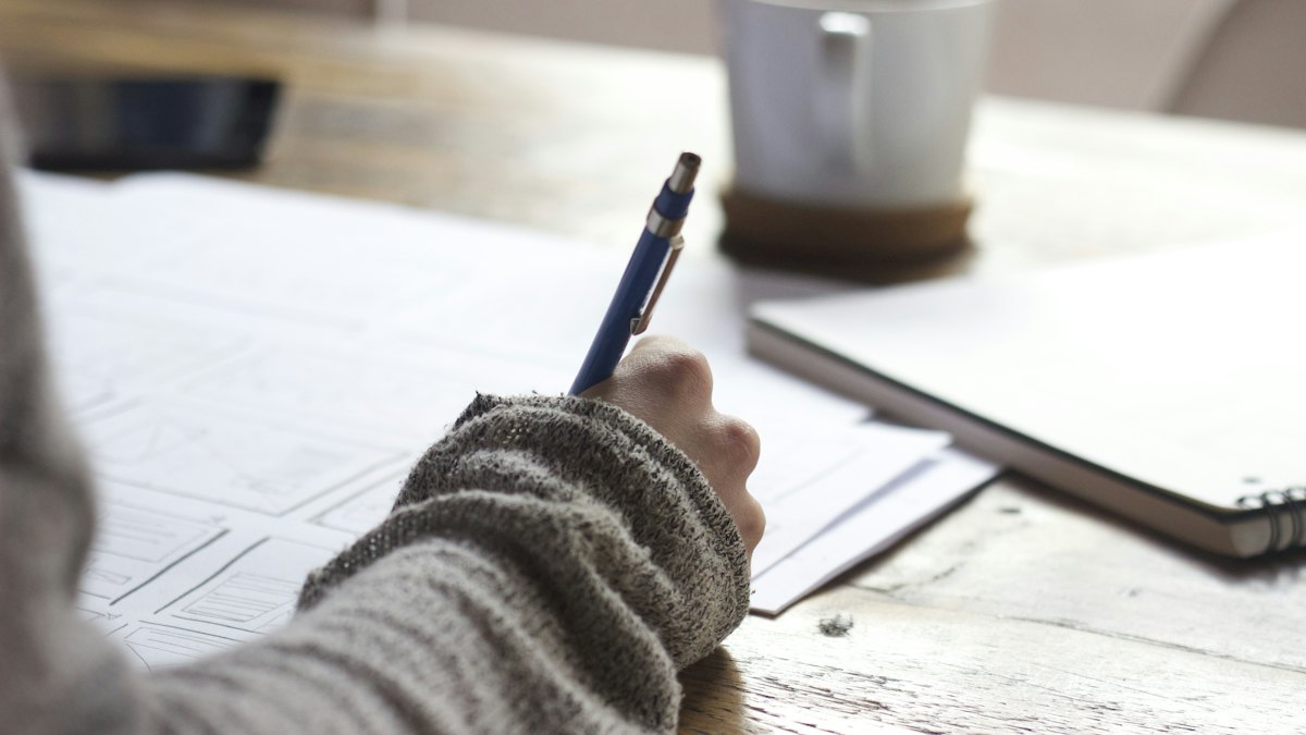 Close-up of a hand writing with a pen on paper