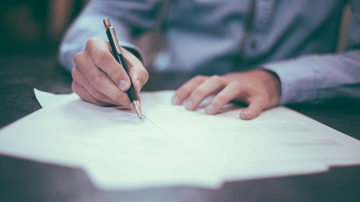 Person writing notes by hand at a desk